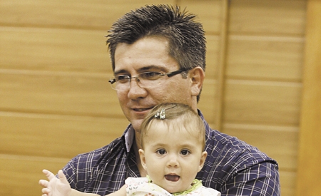 O policial Sandro Soares Rocha segura a pequena Lívia em noite de homenagem na Câmara